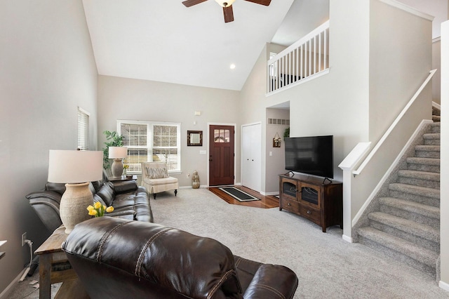 carpeted living area featuring visible vents, baseboards, stairway, high vaulted ceiling, and a ceiling fan