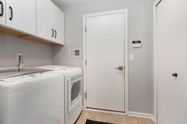 laundry room with visible vents, cabinet space, separate washer and dryer, and baseboards