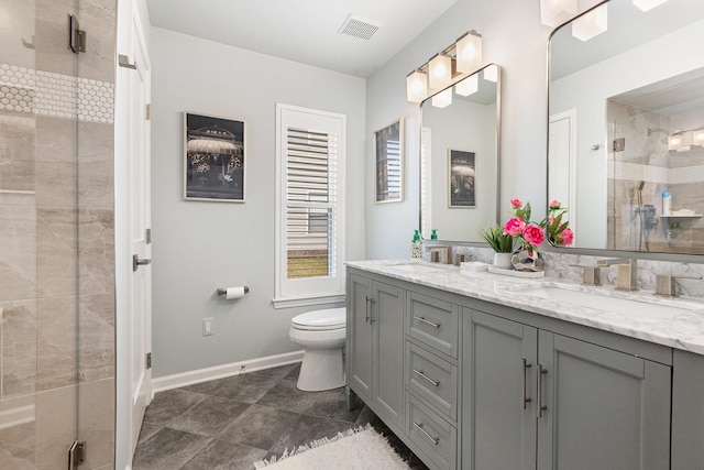 bathroom with visible vents, a shower stall, toilet, double vanity, and a sink