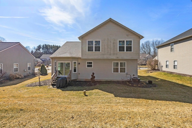 back of house featuring entry steps, central air condition unit, and a lawn