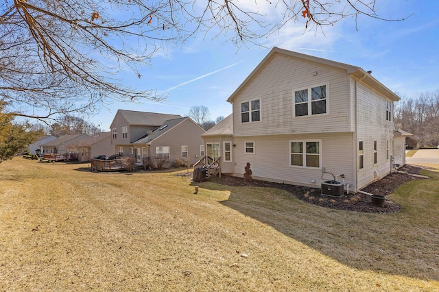 rear view of house featuring central AC and a yard