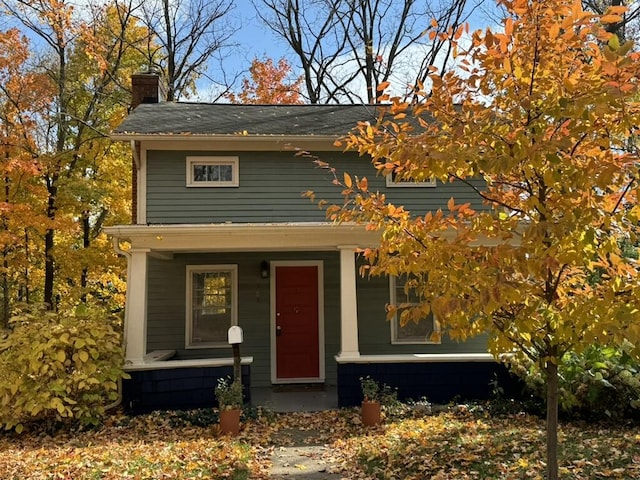 view of front of house with covered porch and a chimney