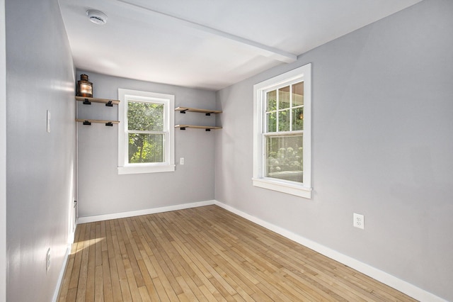 unfurnished room with baseboards and wood-type flooring