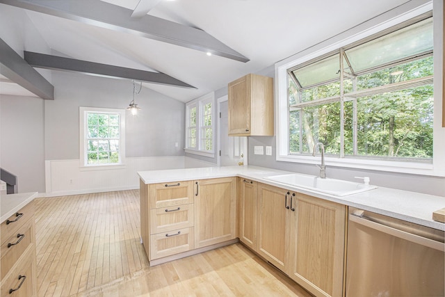 kitchen featuring vaulted ceiling with beams, light brown cabinetry, wainscoting, stainless steel dishwasher, and a sink