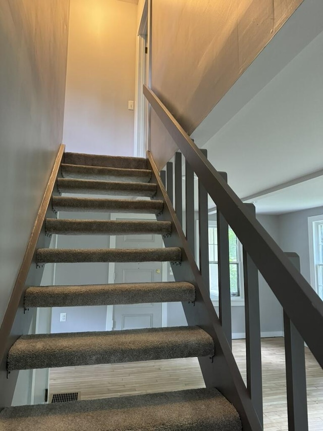 staircase with wood finished floors and baseboards