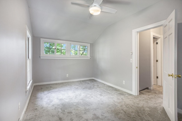 unfurnished bedroom with a ceiling fan, lofted ceiling, carpet, and baseboards