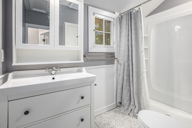 full bath with vanity, toilet, a shower with curtain, and a wainscoted wall