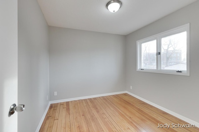 empty room with light wood finished floors and baseboards