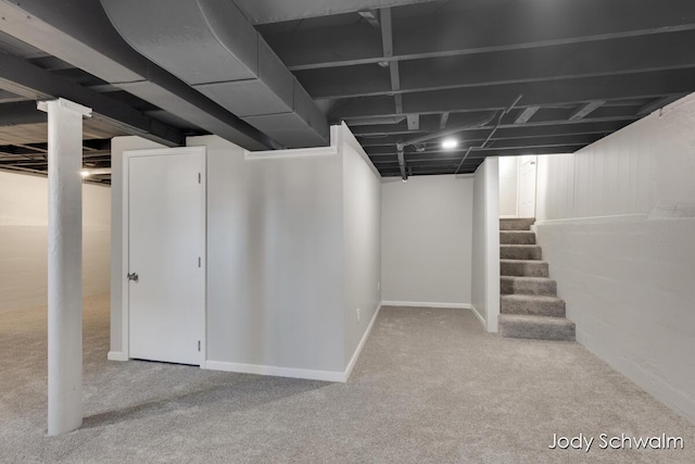 finished basement featuring stairway and carpet floors