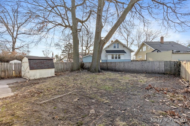 view of yard featuring a shed, an outdoor structure, and a fenced backyard