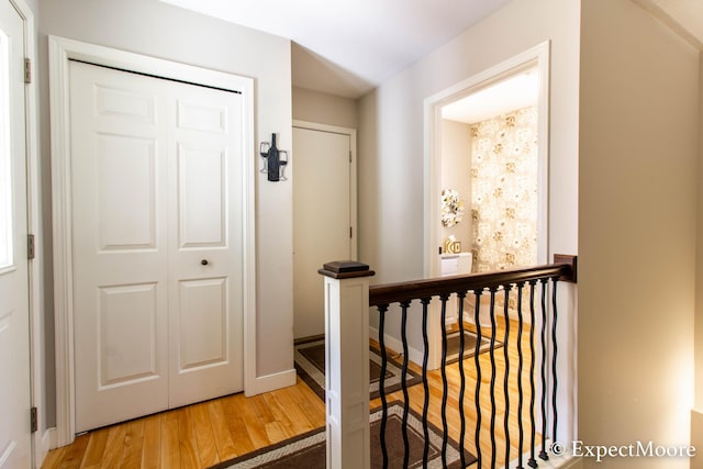 hallway featuring an upstairs landing and wood finished floors