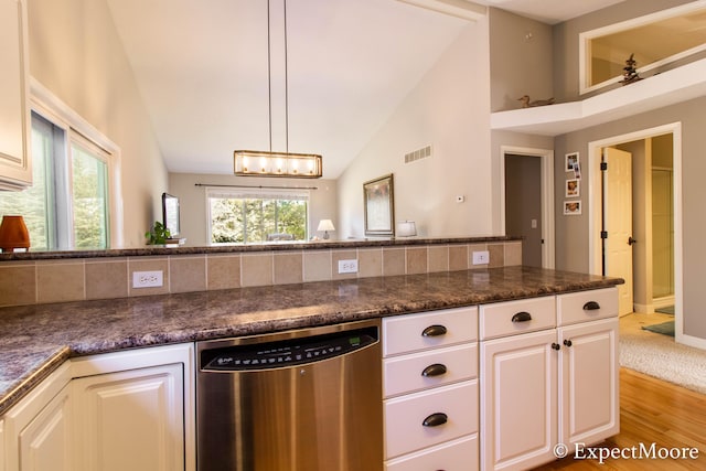 kitchen featuring light wood finished floors, visible vents, dishwasher, lofted ceiling, and white cabinetry