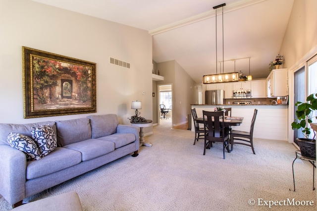 living room featuring light colored carpet, visible vents, and high vaulted ceiling