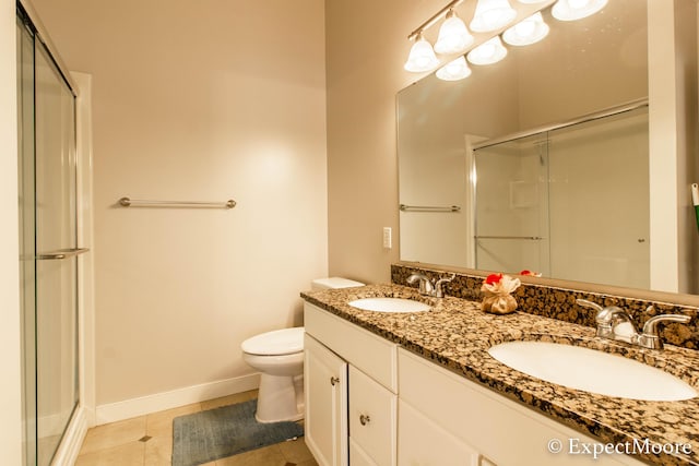 bathroom featuring a sink, toilet, and a shower stall