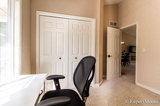 carpeted office space with visible vents and baseboards