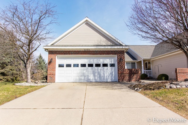 view of front of home featuring brick siding, an attached garage, and concrete driveway