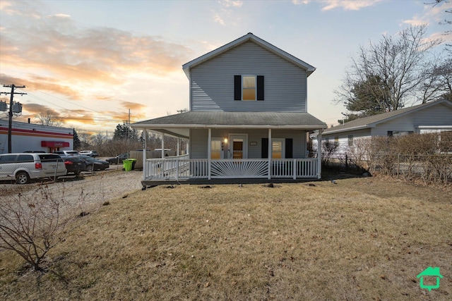 view of front of property with a yard, fence, and covered porch