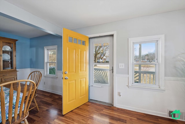 entryway with visible vents, wainscoting, and wood finished floors