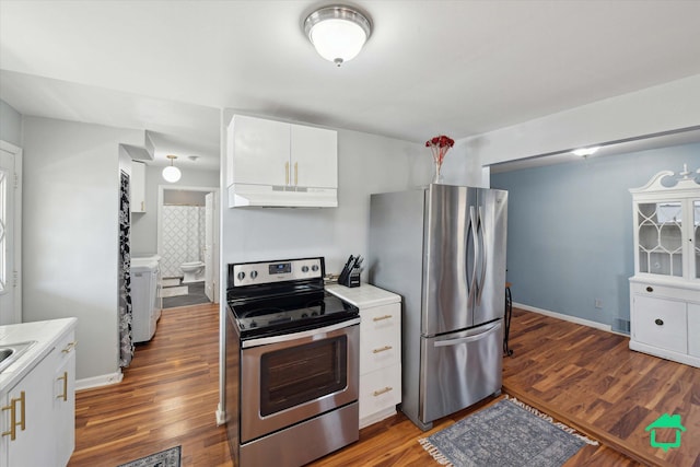 kitchen with under cabinet range hood, wood finished floors, white cabinetry, stainless steel appliances, and baseboards