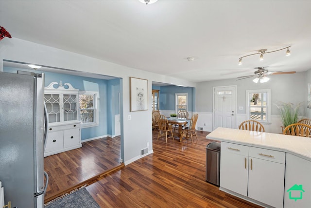 kitchen with dark wood finished floors, visible vents, white cabinetry, and freestanding refrigerator