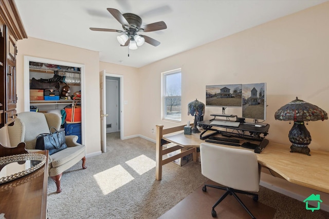 carpeted office featuring a ceiling fan and baseboards