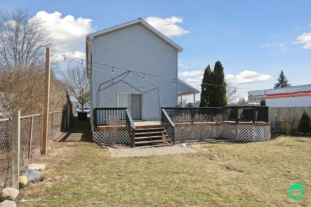 rear view of property with a yard, a wooden deck, and a fenced backyard