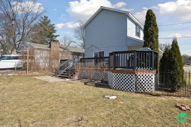 back of property with a lawn, a deck, and fence