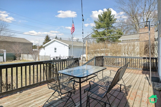 wooden deck with outdoor dining space and an outbuilding