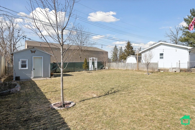 view of yard featuring an outbuilding, a storage unit, and a fenced backyard