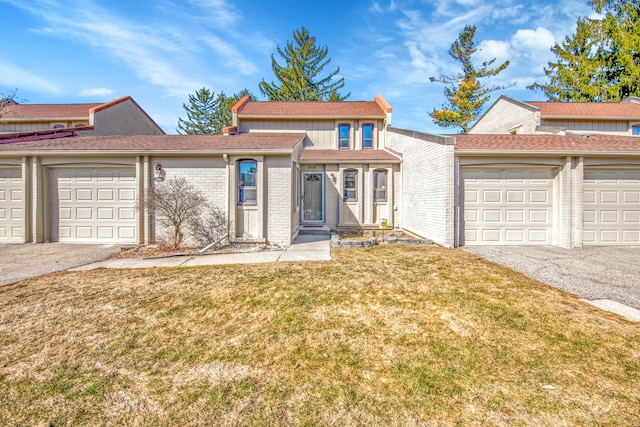 view of front of house featuring a garage, driveway, brick siding, and a front lawn