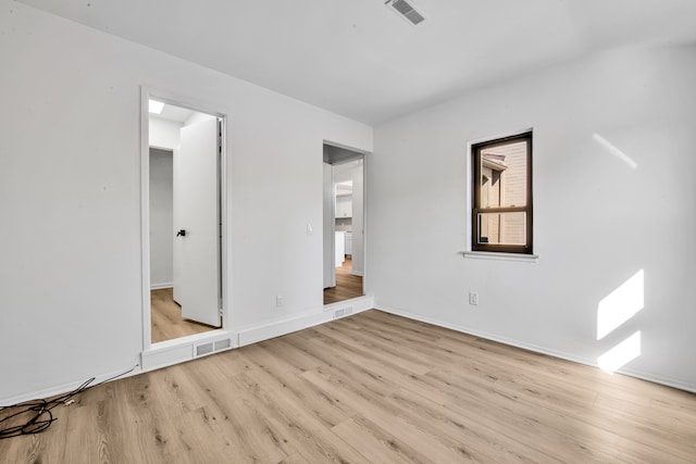 unfurnished bedroom featuring light wood finished floors, visible vents, and baseboards