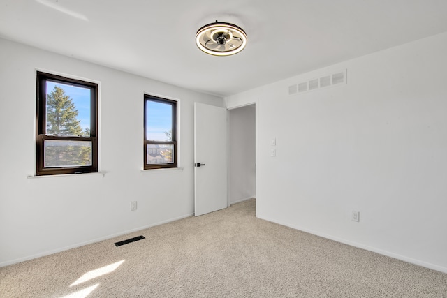 empty room with visible vents, baseboards, and carpet flooring