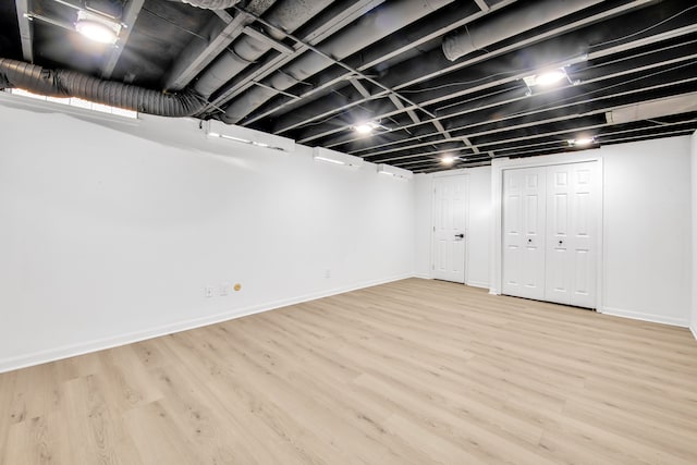 finished basement with light wood-type flooring and baseboards