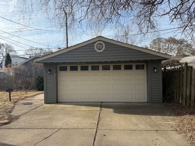 detached garage featuring fence