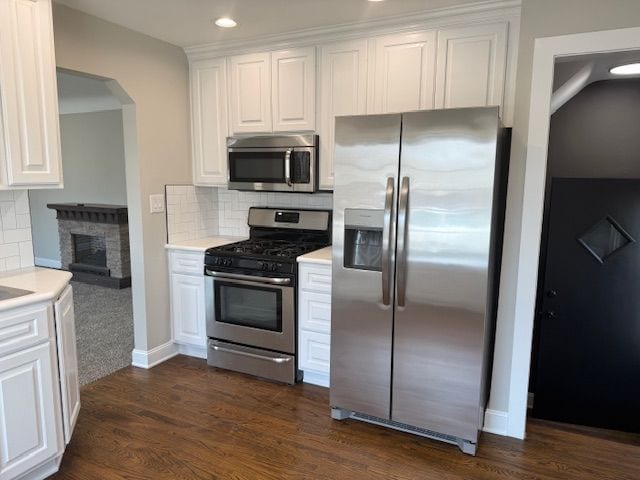 kitchen with white cabinetry, light countertops, decorative backsplash, and stainless steel appliances