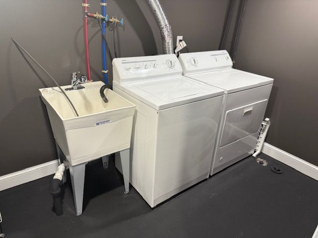 laundry area with a sink, baseboards, and separate washer and dryer