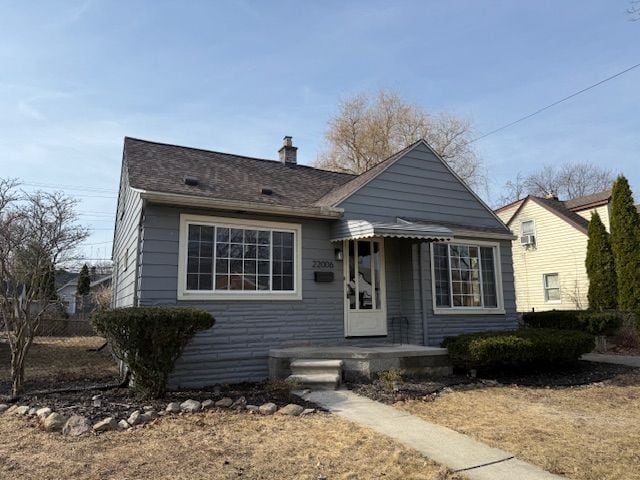 bungalow featuring a chimney and fence