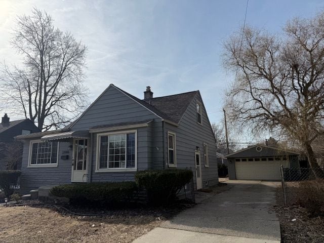 view of front of home with a garage, a chimney, and an outdoor structure