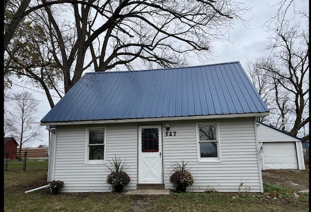 exterior space with an outbuilding, fence, a garage, and metal roof