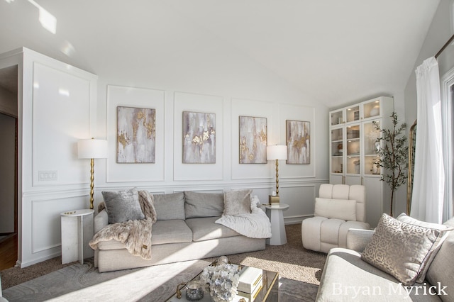 carpeted living area with vaulted ceiling and a decorative wall