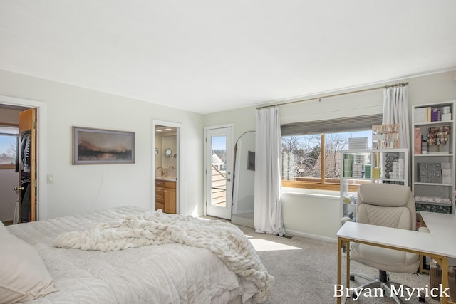 carpeted bedroom with a sink, baseboards, and access to outside