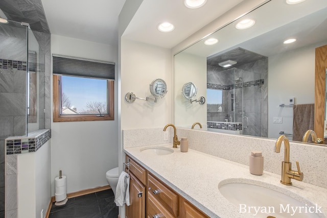 bathroom featuring a sink, toilet, a stall shower, and double vanity