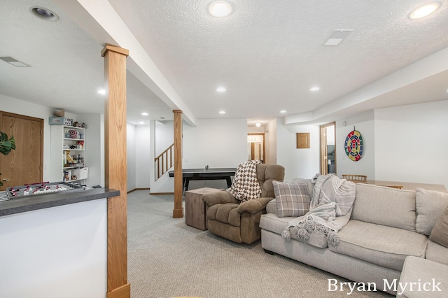 living area with visible vents, a textured ceiling, recessed lighting, stairway, and light colored carpet