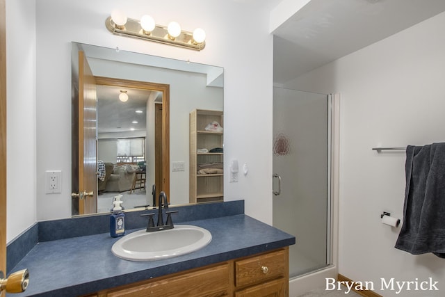 bathroom with a shower stall, vanity, and connected bathroom