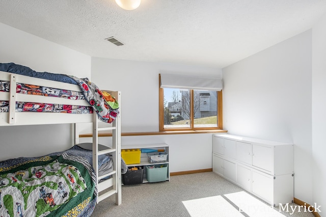 bedroom with light carpet, visible vents, a textured ceiling, and baseboards