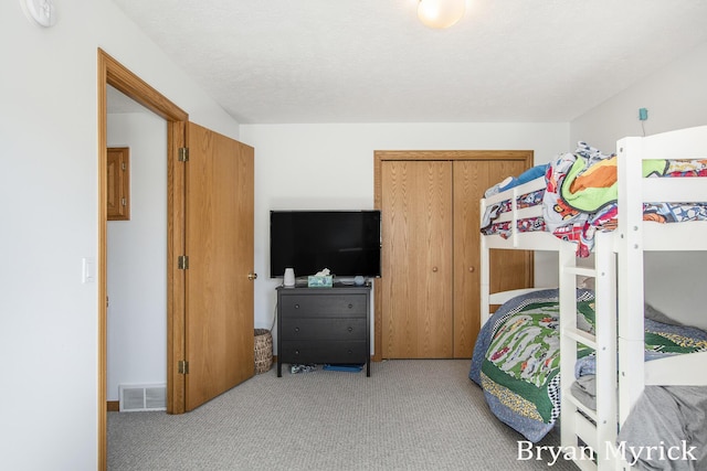 bedroom with visible vents and light carpet