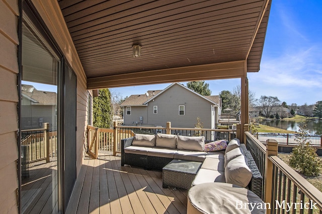 wooden terrace with a water view and an outdoor hangout area