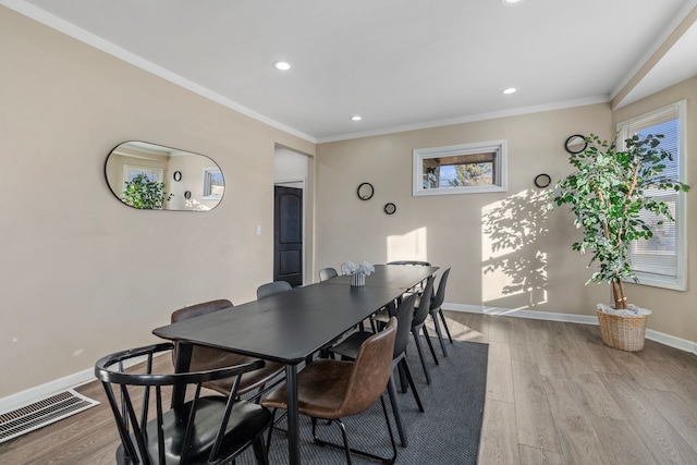 dining area featuring visible vents, ornamental molding, and wood finished floors