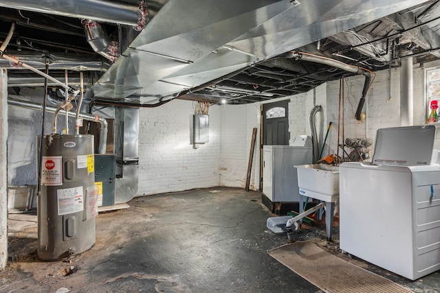 basement featuring heating unit, electric panel, independent washer and dryer, and electric water heater