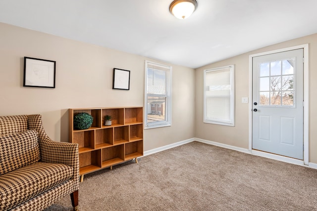 entrance foyer with vaulted ceiling, baseboards, and light carpet